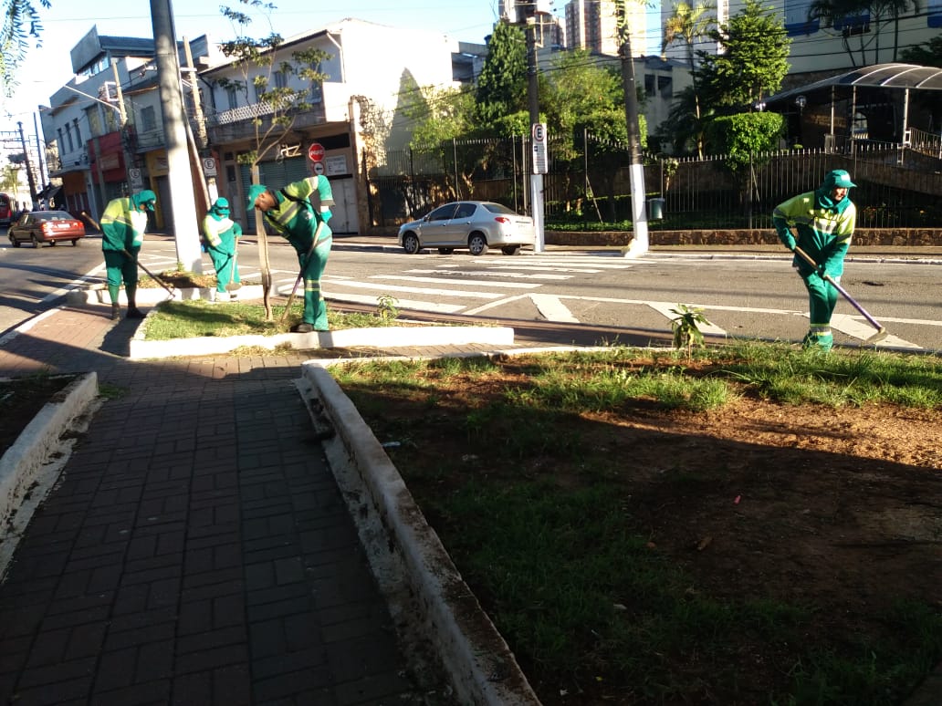 pessoas capinando a calçada